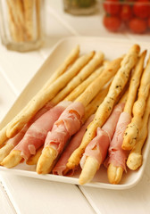 Italian bread sticks grissini with pork and ham