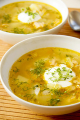 Salmon soup with onion and herbs egg in white bowl