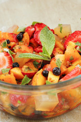 Berries and fruit salad with slices of jelly and mint sauce