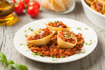 Italian pasta Conchiglioni Rigati stuffed with dry tomatoes and meat.