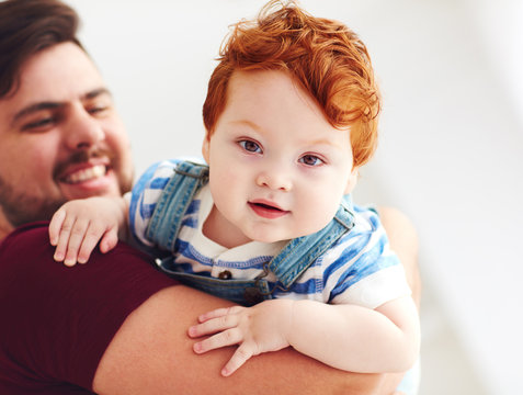 Portrait Of Adorable Red Head Infant Baby Boy On Father's Hand