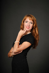 Portrait of red-haired girl in a black dress