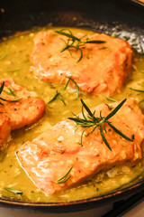 Baked salmon orange and rosemary saucein black pan