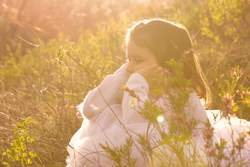 Little girl with spring flowers in nature