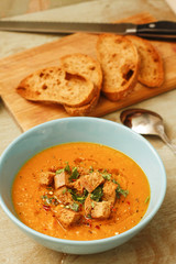 Pumpkin soup with bread on wooden table
