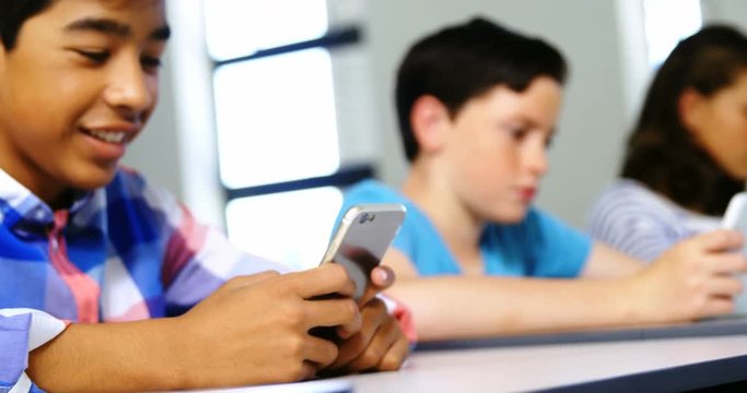 Students using digital tablet and mobile phone in classroom