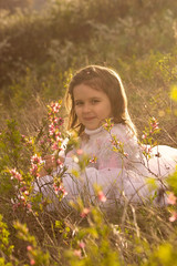 Little girl with spring flowers in nature