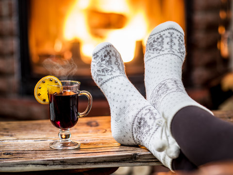 Warming and relaxing near fireplace with a cup of hot wine.