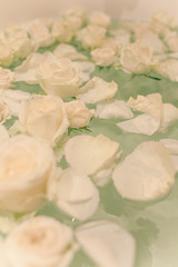 Take a bath with rose petals and candles. Romantic evening in the bathroom with wine and candles