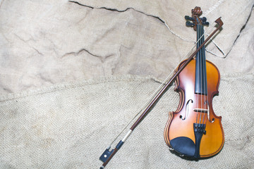 beautiful violin rests on an old piece of material.