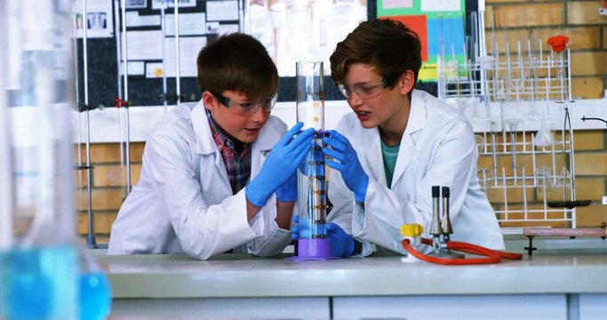 School boys doing chemical experiment in laboratory at school