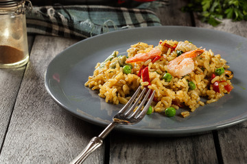 Traditional seafood paella with shrimp, fish and chicken seved in plate.