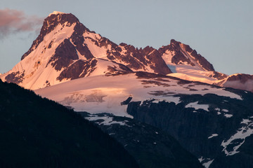 Fototapeta na wymiar Snow-capped peak in Coast Mountain range, British Columbia, Canada during sunset