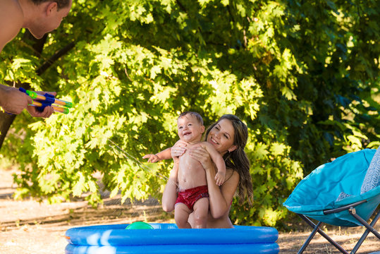Summer family vacation in the garden and play with water gun