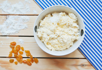 Making of russian style breakfast syrniki or cottage cheese pancakes ingredients on wooden table.
