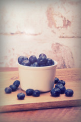 Pot of blueberries on a rustic background