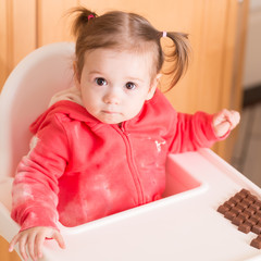 Dirty girl.Adorable little girl with dirty face and clothes eating chocolate