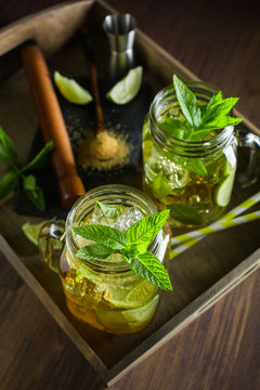 Mojito served on wooden tray with lime and mint