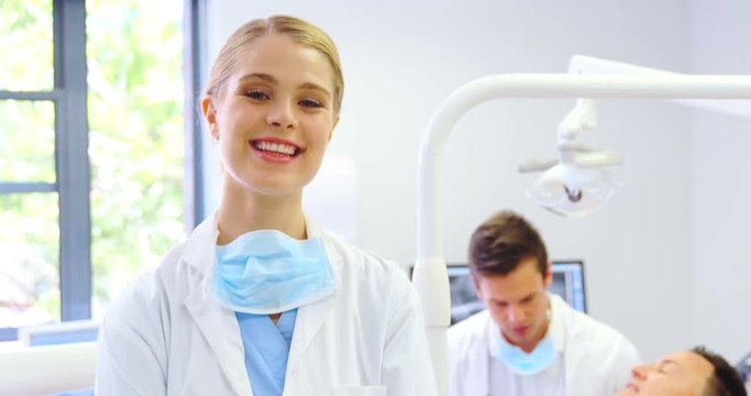 Portrait of smiling dentist standing with arms crossed