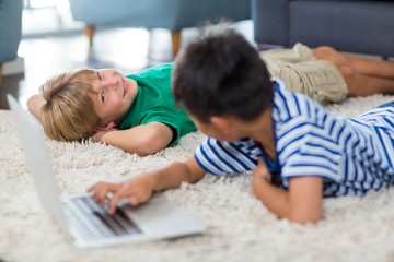 Siblings interacting with each other while using laptop