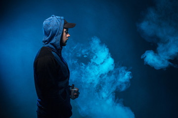 vaping man holding a mod. A cloud of vapor.