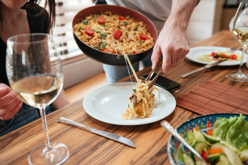 Man cooking dinner and putting food into the plate