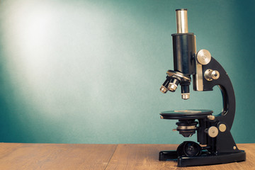 Vintage old microscope on table for science background