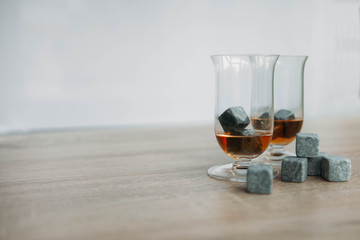 Stones for cooling whiskey and glases tulup on light wooden background