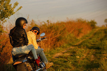 Beautiful young couple with a classic motorcycle