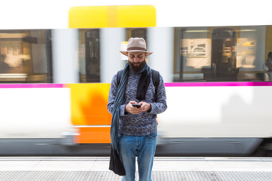 Man using smartphone while standing on railway platform