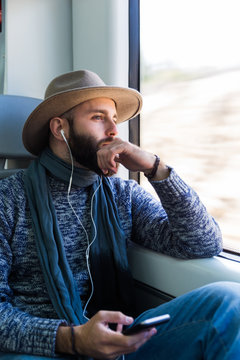 Young man listening to music while sitting in train