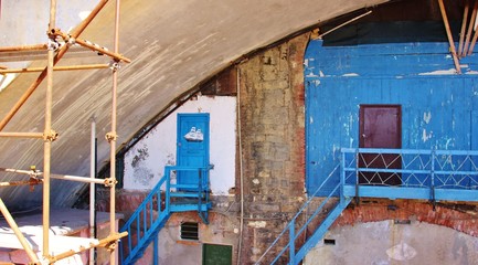 Grungy old fishing shacks under the Genoa Nervi Promenade and railway in Italy