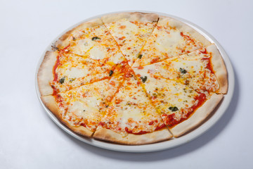 Italian delicious pizza with cheese on a white plate