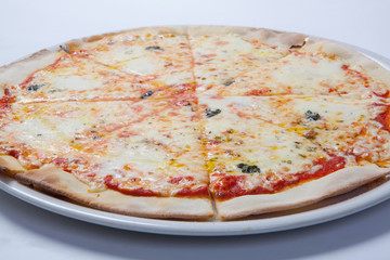 Italian delicious pizza with cheese on a white plate