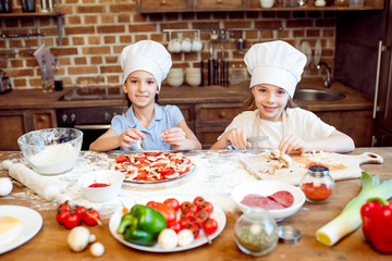 kids in chef hats making pizza together