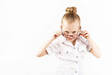 Funny little girl wearing eyeglasses imitates a strict teacher against white background