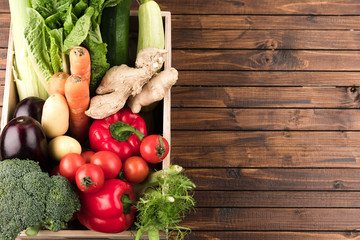 fresh seasonal vegetables in wooden box on wooden table background