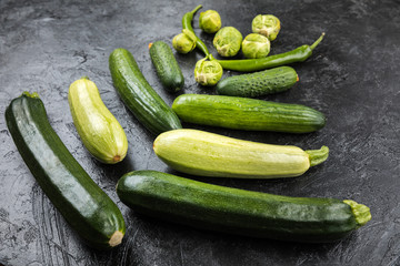 different green fresh seasonal vegetables on black table top background