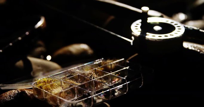 Fly fishing rod, reel and fishing bait on rock