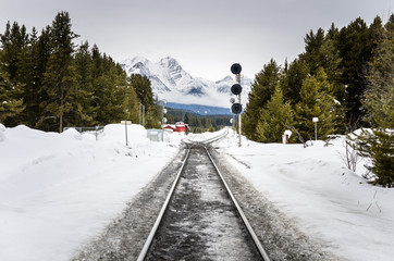 Railway covered in Snow in a Mountain Landscape on a Cloudy Winter Day