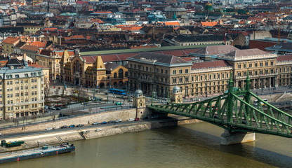 Fototapeta premium Square near Great Market Hall and Liberty Bridge over Danube river by day in Budapest, Hungary. Cityscape of Pest side view from Gellert Hill