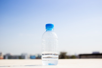 Water bottle left on the table in sky and city blured background.