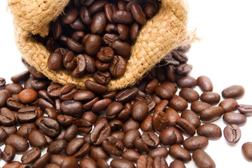 Organic coffee beans in sack on white background close up isolated.