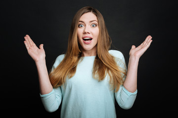 Surprised young woman expressing astonishment in the studio