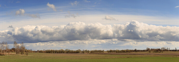 Field against the sky with clouds in the spring