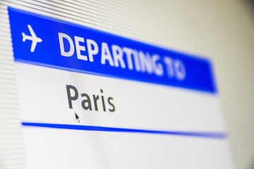 Computer screen close-up of status of flight departing to Paris, France