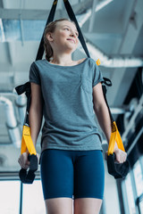 preteen girl training with resistance bands in fitness class. gym class kids concept