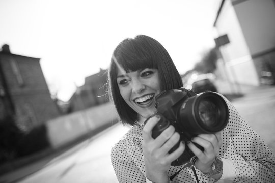 Attractive young woman smiling with a camera.