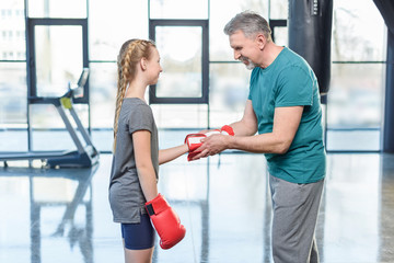 preteen girl boxing with senior trainer. Fitness manager, gym class kids concept