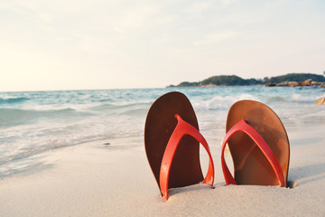 Red sandal on rock and sea background concept time to travel , holiday summer season